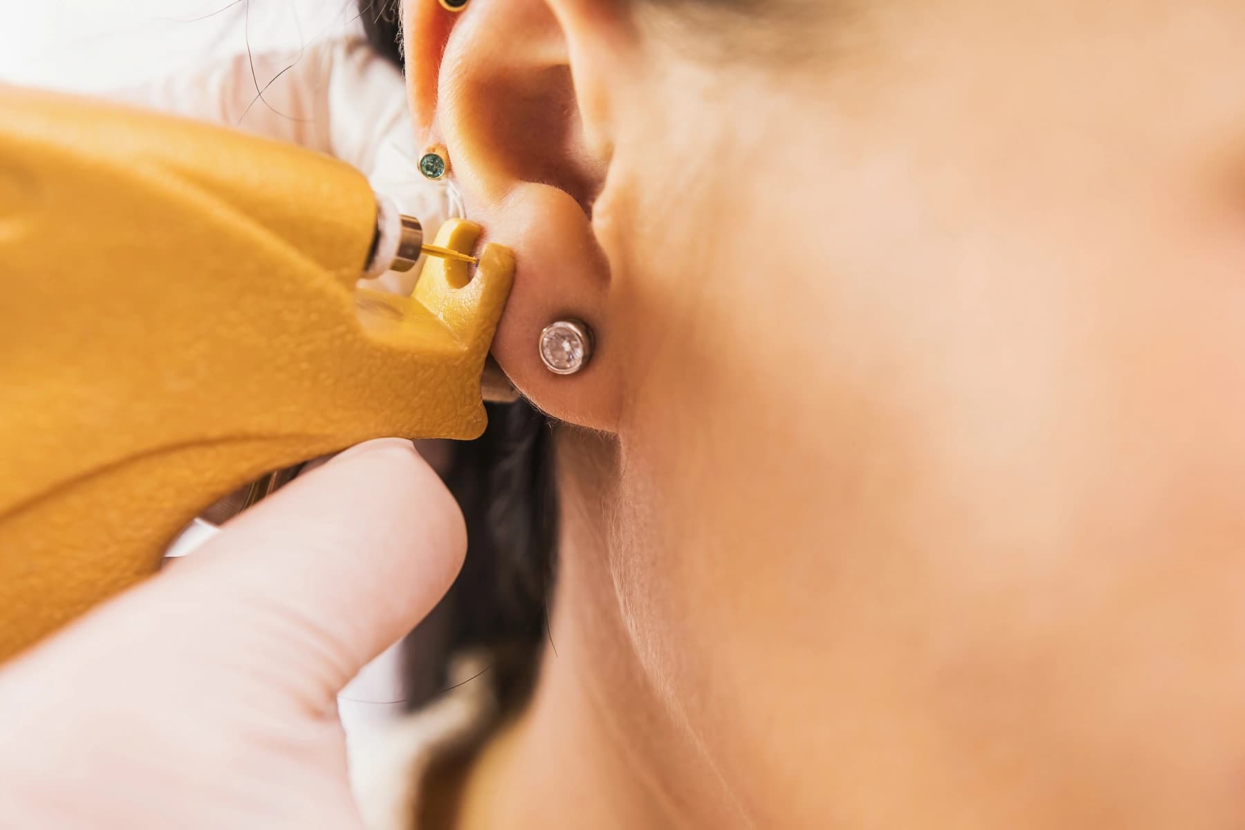 Pharmacy team member marking a patient's earlobe with a surgical pen before piercing.